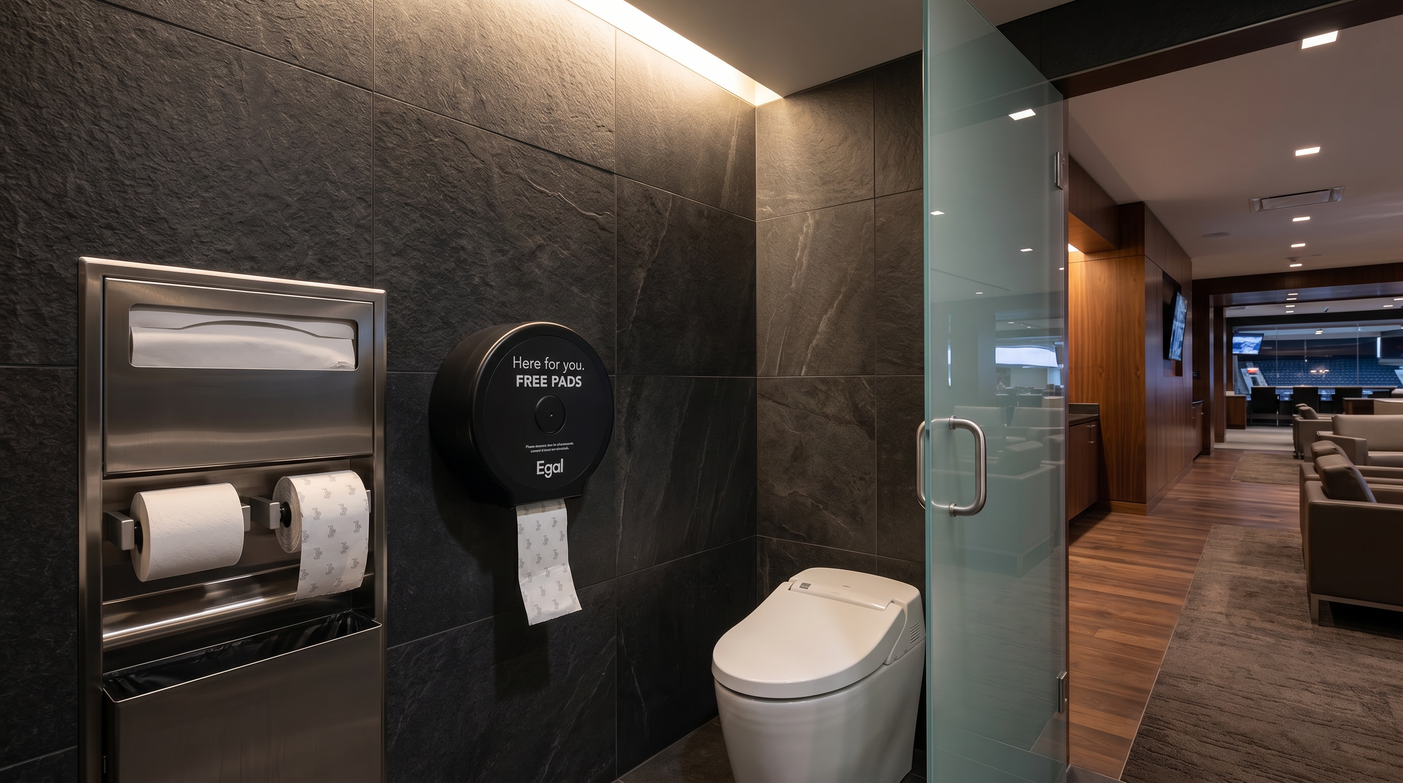 An Egal Pads on a Roll dispenser mounted next to the toilet paper dispenser in a modern restroom